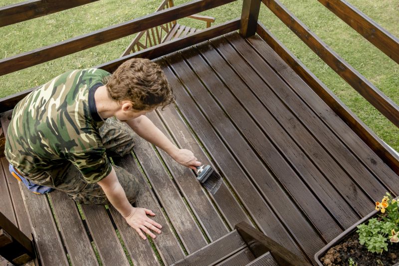 Applying stain to deck railings
